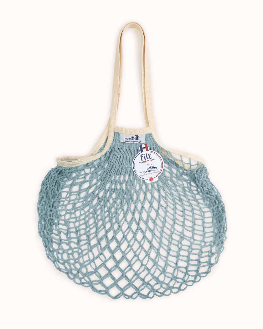 Light blue mesh bag with beige handle on a white background. By Filt 1860 x Mont St. Michel, available at Wildschut Antiques.