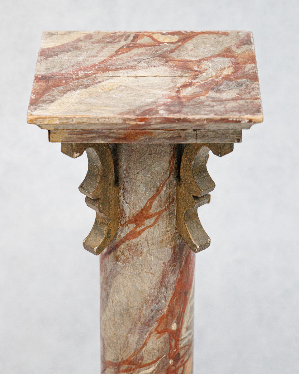 Close-up of a decorative faux marble wooden column or pedestal with intricate design on a white background