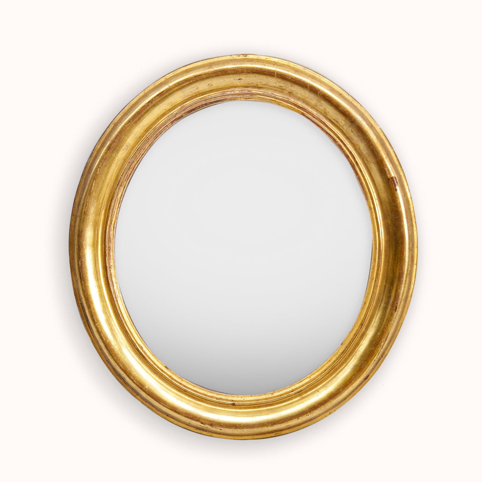 Lovely small antique gold oval mirror on a white background, available via Wildschut Antiques