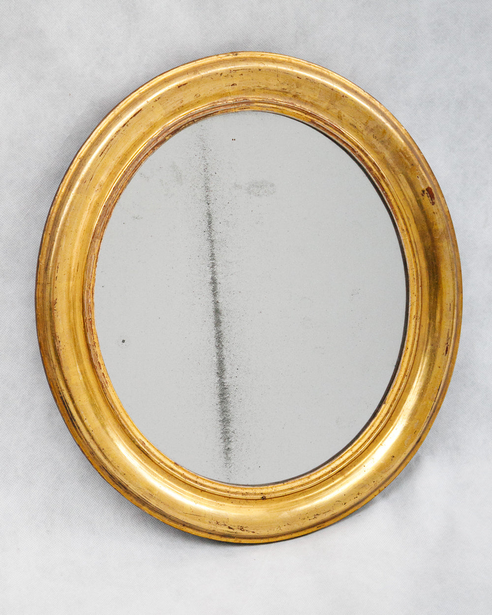 Lovely small antique gold oval mirror with foxed glass, available via Wildschut Antiques