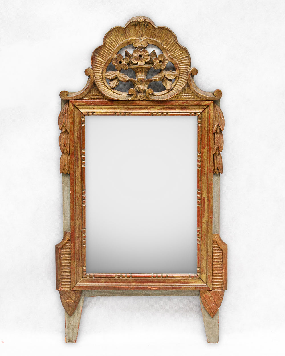 Detail of a decorative antique gold gilt wooden marriage mirror with intricate flower carvings on a white background, available via Wildschut Antiques