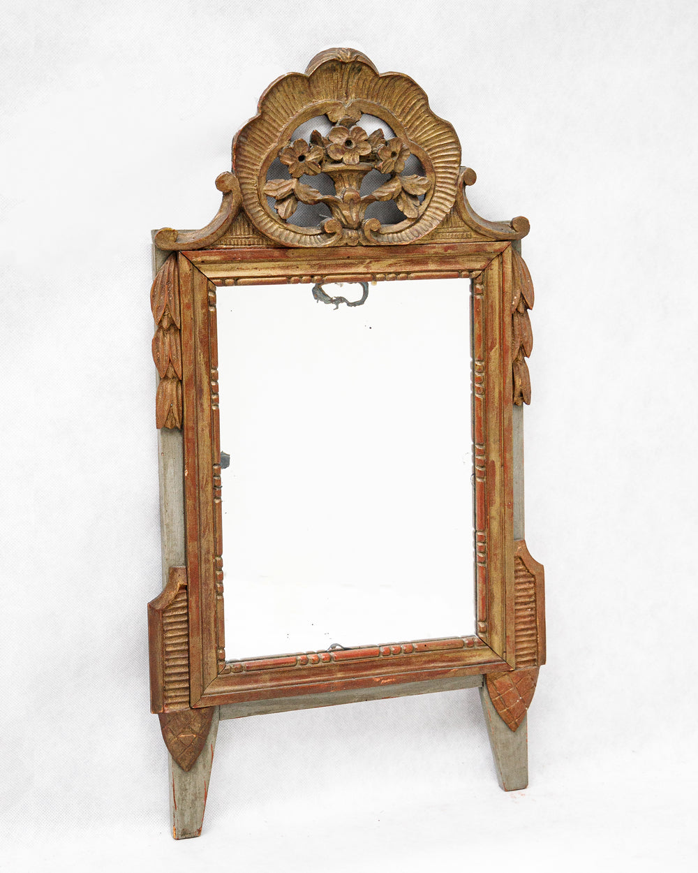 Sideview of a decorative antique gold gilt wooden marriage mirror with intricate flower carvings on a white background, available via Wildschut Antiques