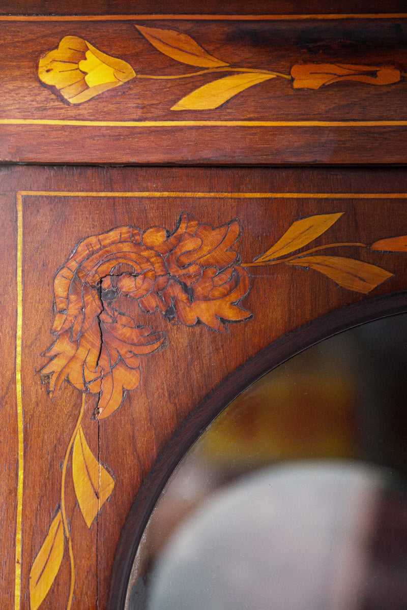 Detail of an antique wooden display cabinet with intricate marquetry floral inlay design