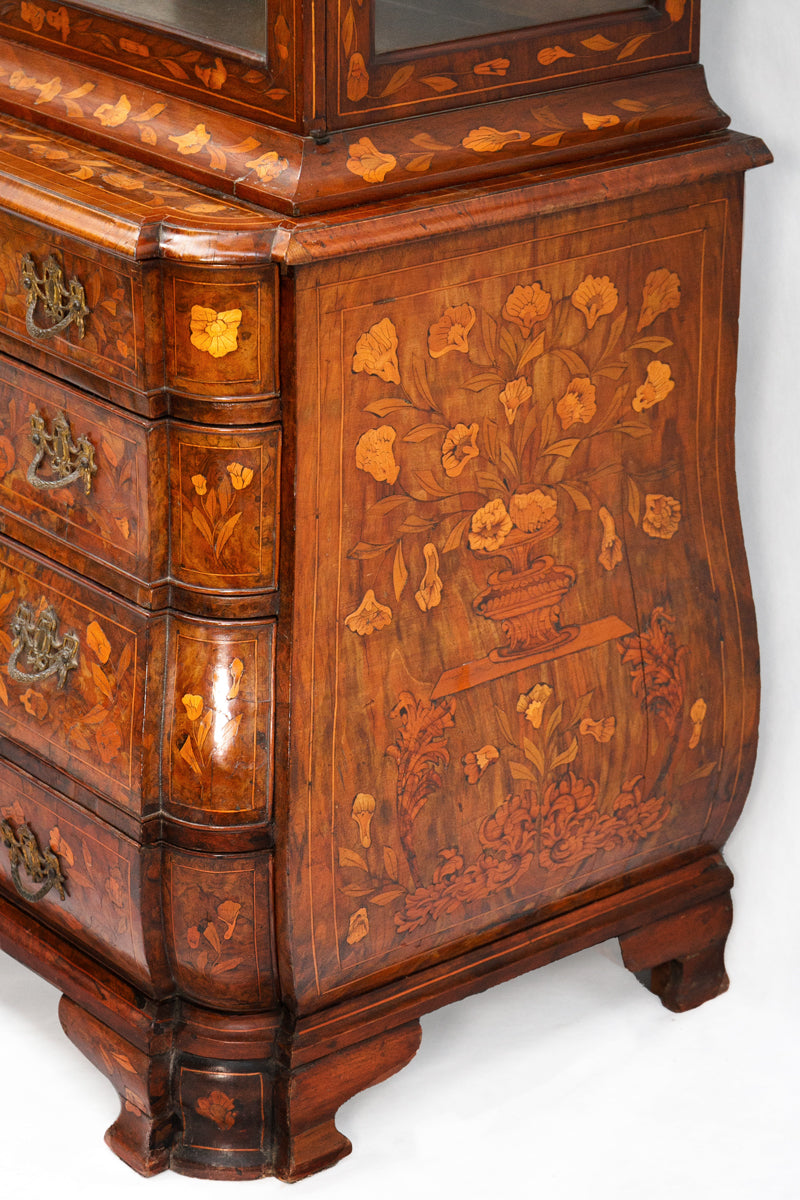 Wooden cabinet with floral marquetry design on a white background available via Wildschut Antiques