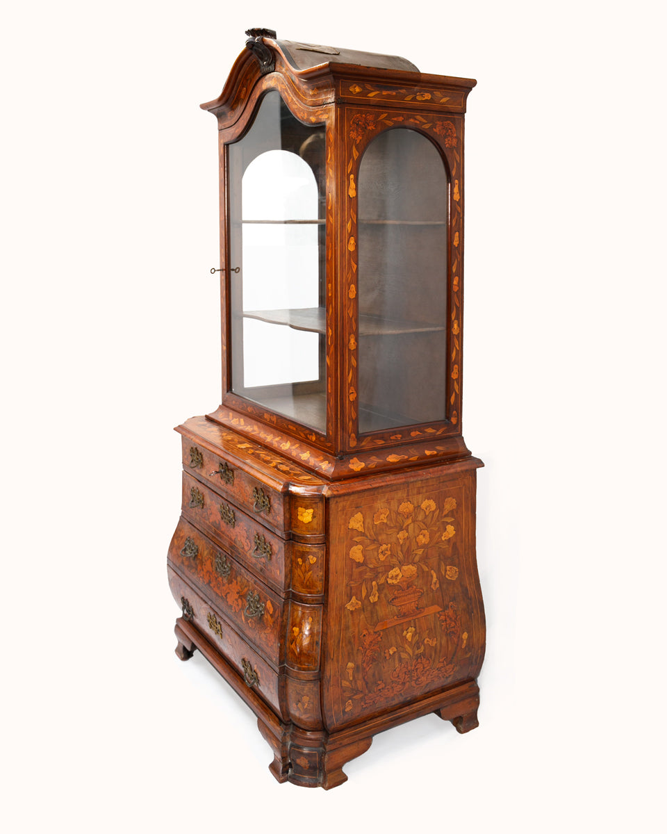 Wooden display cabinet with floral marquetry design on a white background available via Wildschut Antiques
