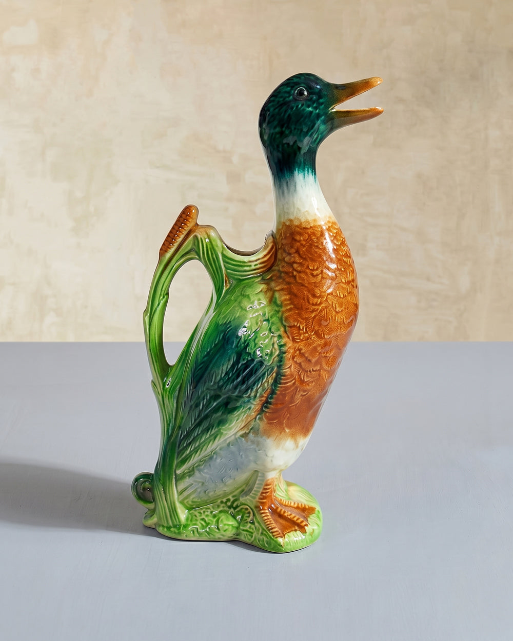 Vintage French ceramic duck water pitcher figurine by St. Clément with colorful glazed detailing, displayed on a plain background, available at Wildschut Antiques.