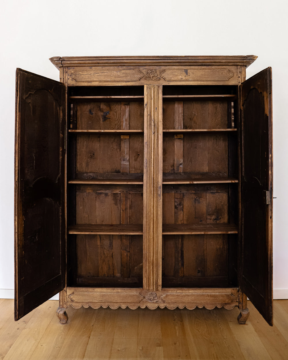 Antique French Louis XV-style armoire featuring star-shaped inlays on the doors, crafted from wood with a visible rustic finish, displayed with two doors open.