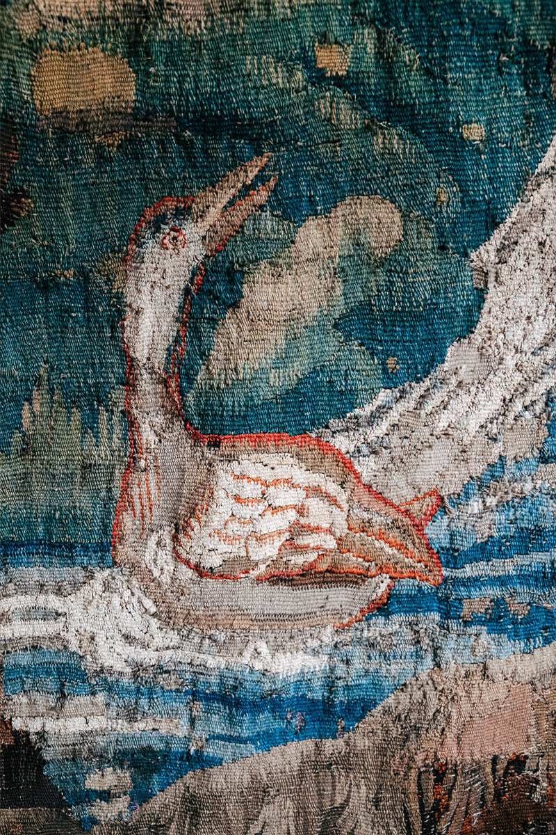 Close-up of a detailed 18th-century Verdure tapestry with a bird design.