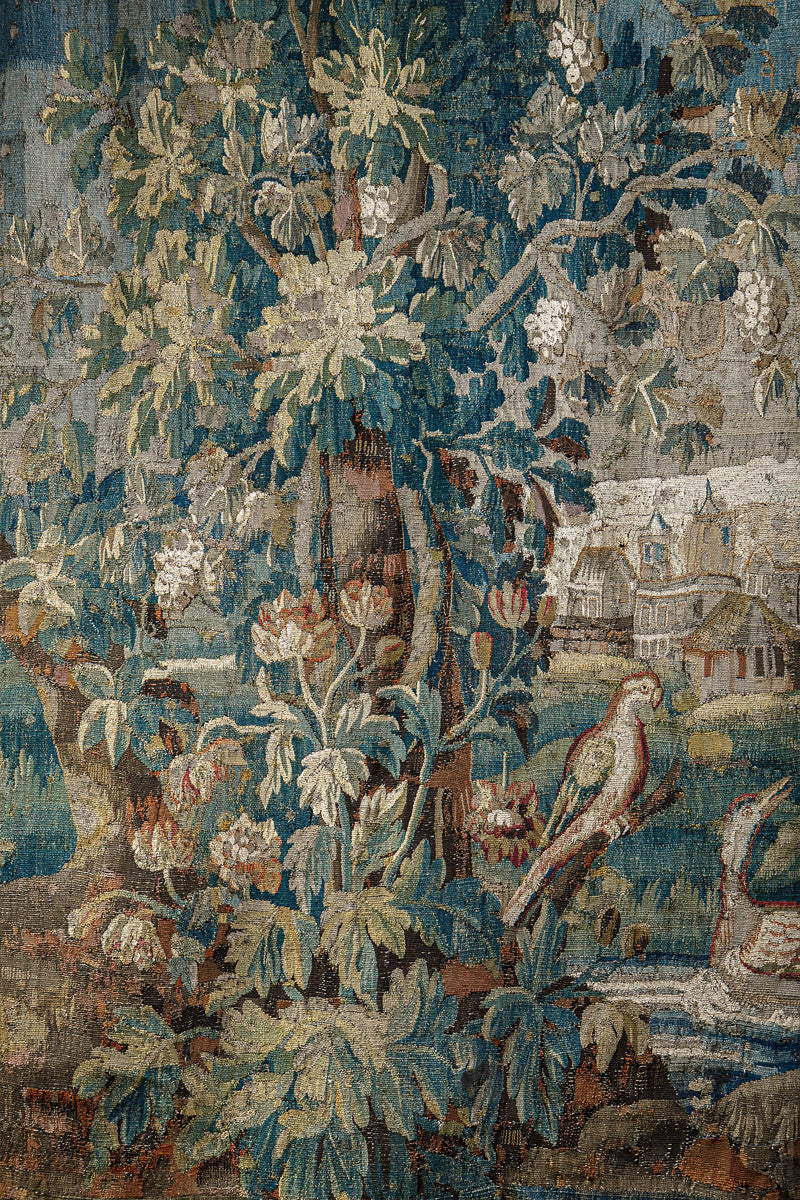Close-up of a decorative 18th-century Verdure tapestry with birds and a large tree.