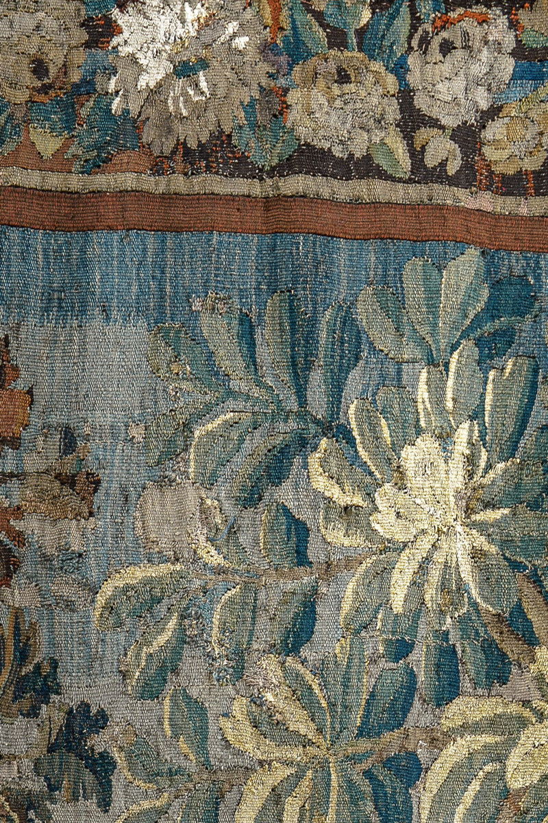 Close-up of a decorative 18th-century Verdure tapestry with flowers and foliage
