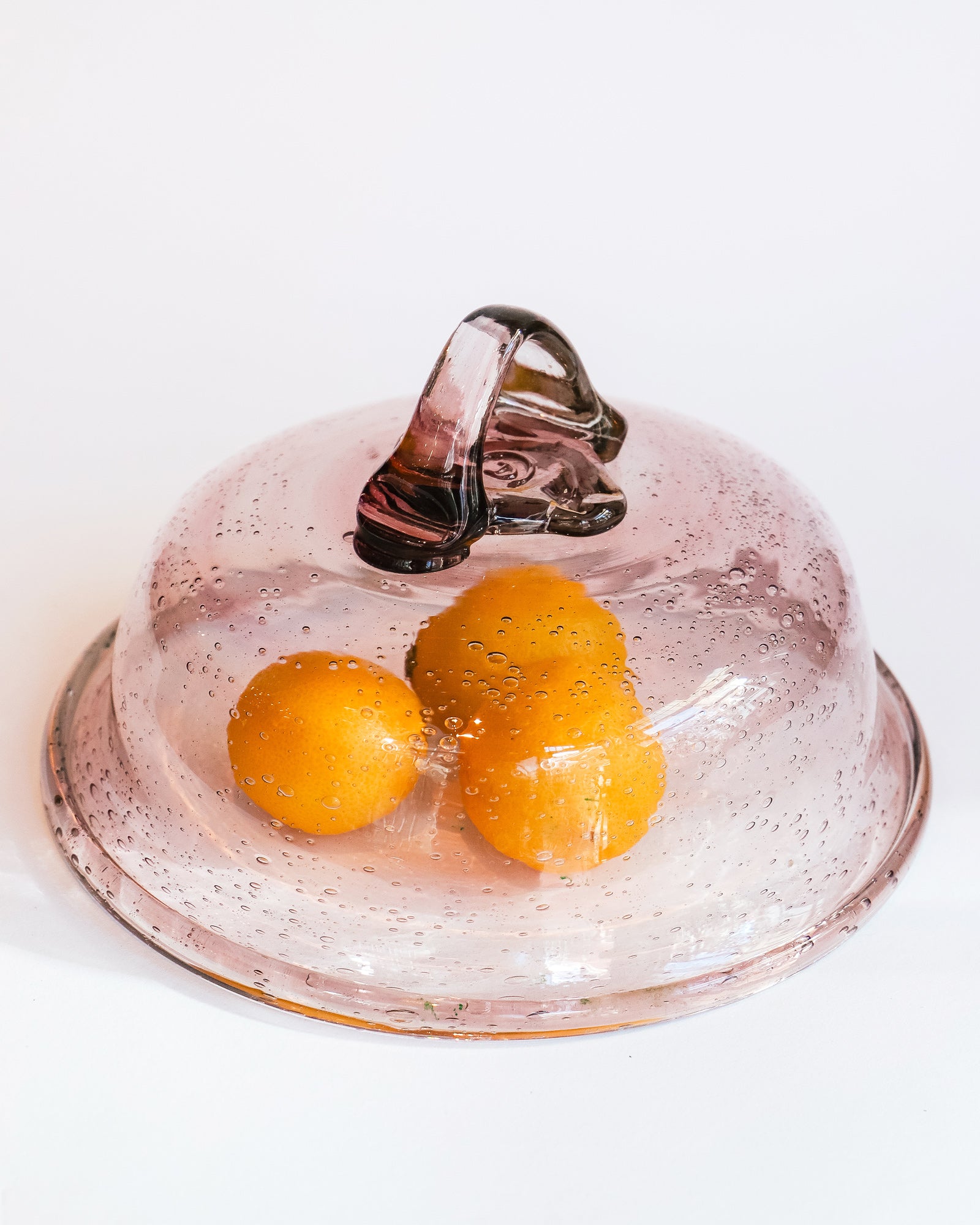 Taupe-colored bubble glass bell dome by Biot, circa 1970s, displayed with three lemons.