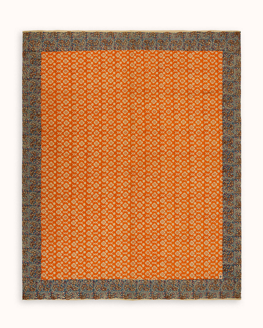 Orange patterned throw or plaid or tablecloth with a floral border on a white background.