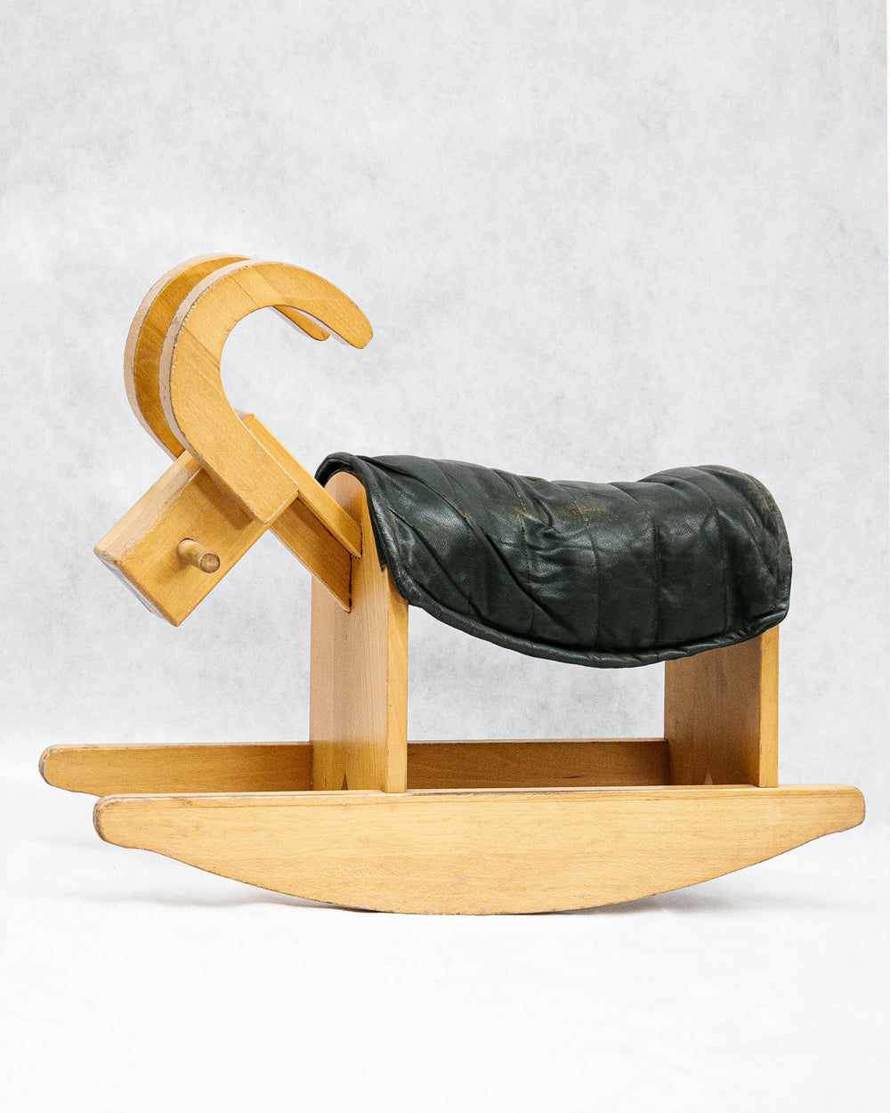 A vintage wooden rocking billy goat with a dark green leather deck, on a white background, available at Wildschut Antiques