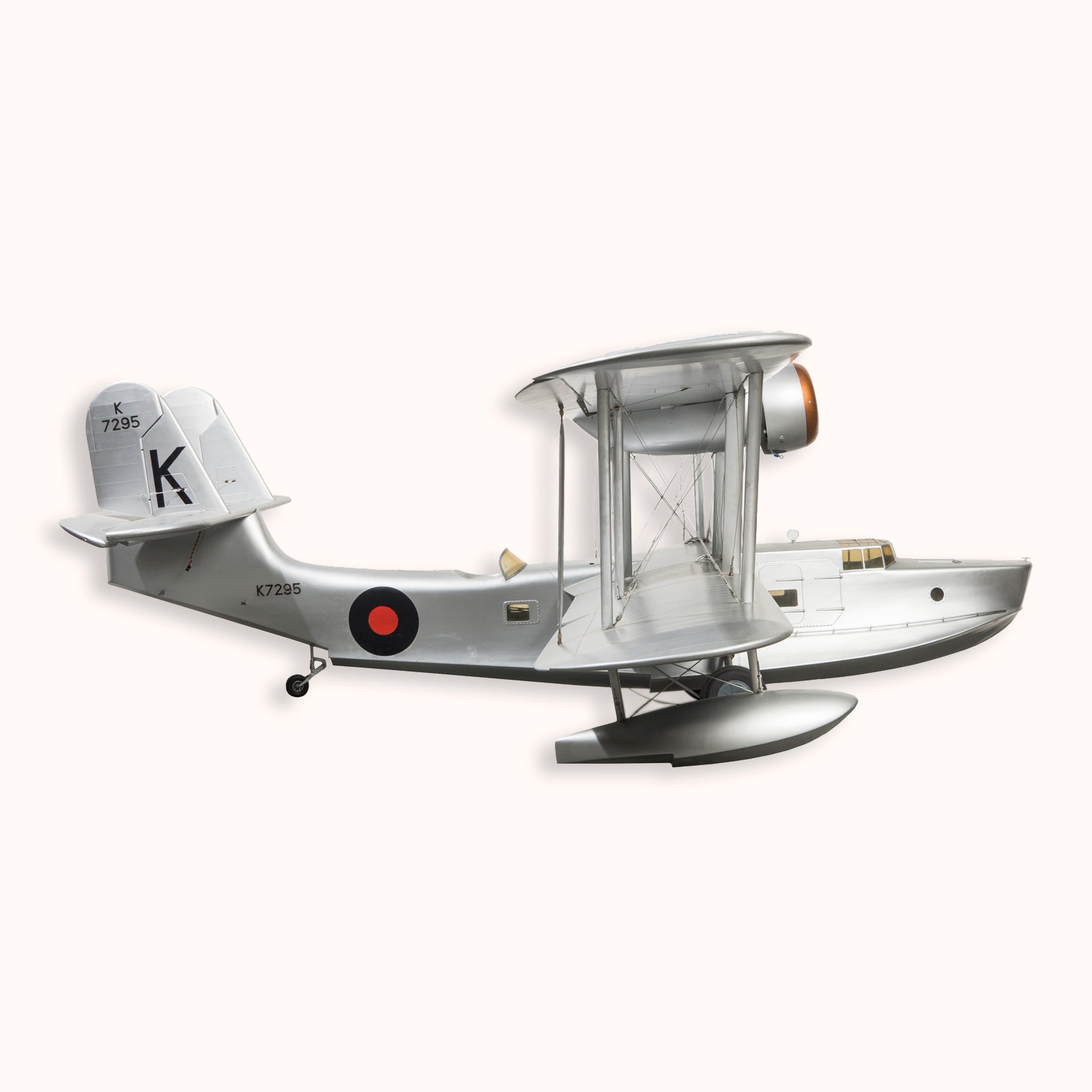 A large vintage model of a World War I-era airplane with a silver finish, black and red detailing, and a large 'K' on the wing, available at Wildschut Antiques