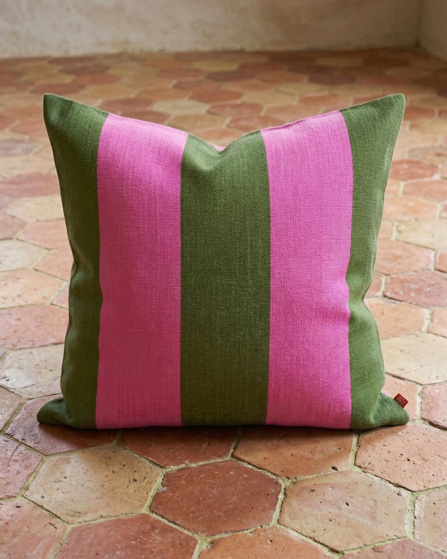 Striped green and pink pillow on a terracotta tiled floor, available via Wildschut Antiques.