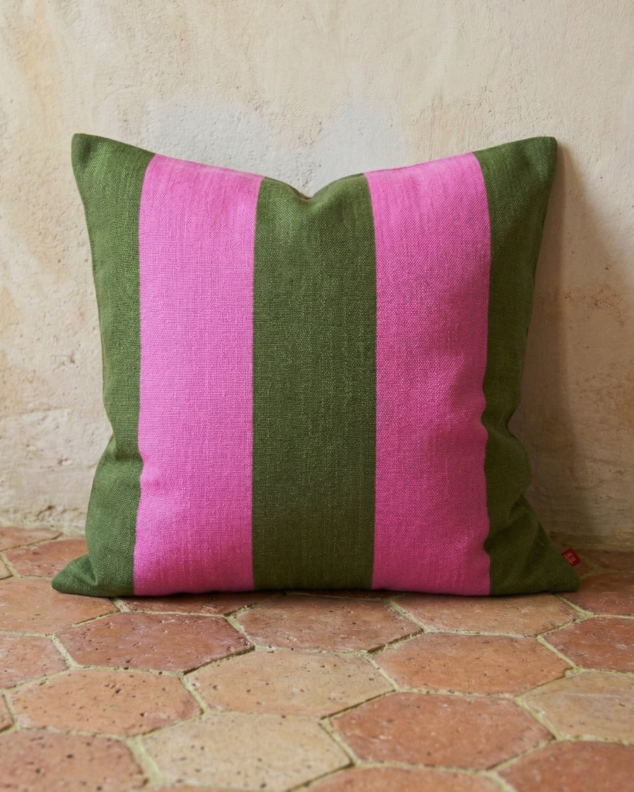 Green and pink striped pillow on a terracotta tiled floor, available via Wildschut Antiques.