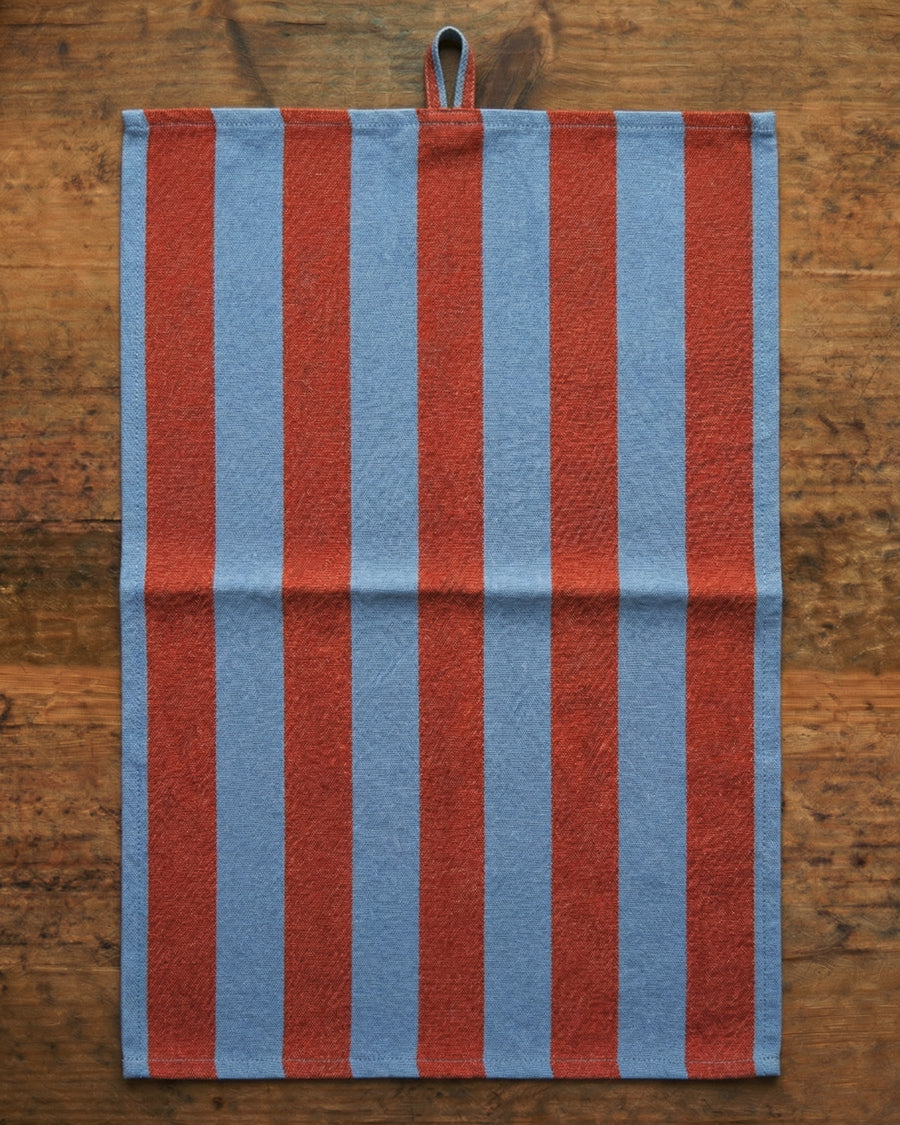 Striped red and blue towel on a wooden surface, available via Wildschut Antiques.