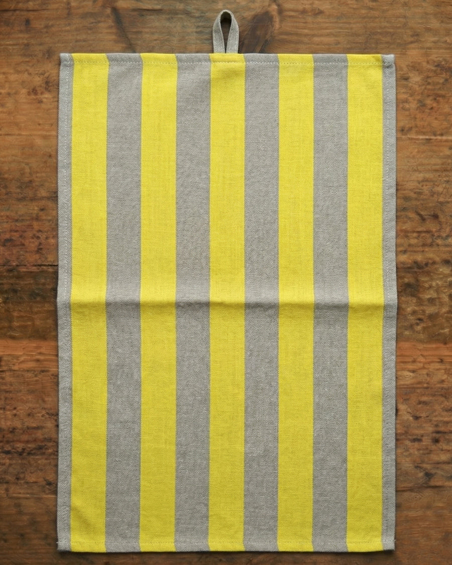 Striped yellow and gray towel on a wooden surface, available via Wildschut Antiques.