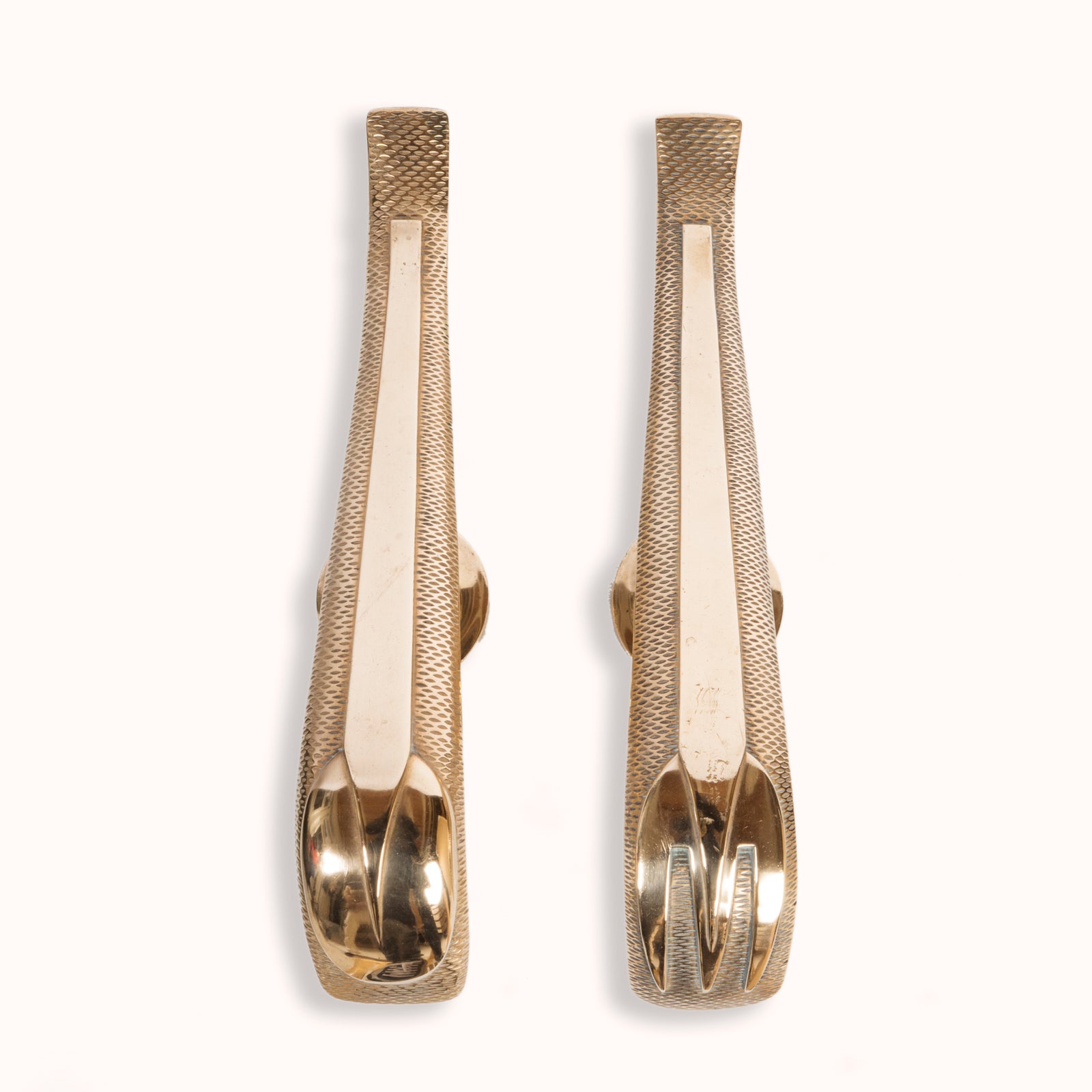 A unique and rare pair of gold-colored Art Deco style door pulls with a spoon and fork design, made of shiny brass, displayed against a white background, available at Wildschut Antiques