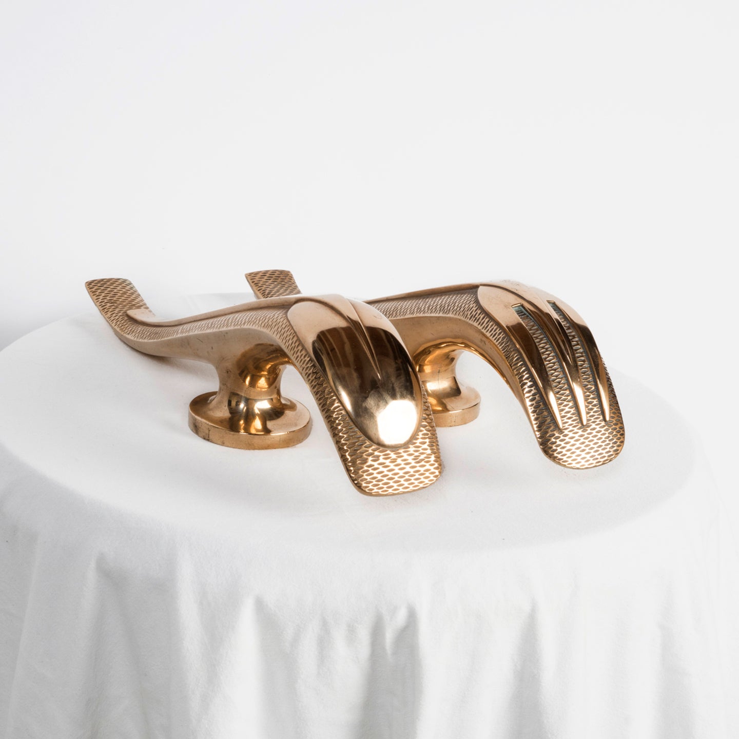 Top sideview of a unique and rare pair of gold-colored Art Deco style door pulls with a spoon and fork design, made of shiny brass