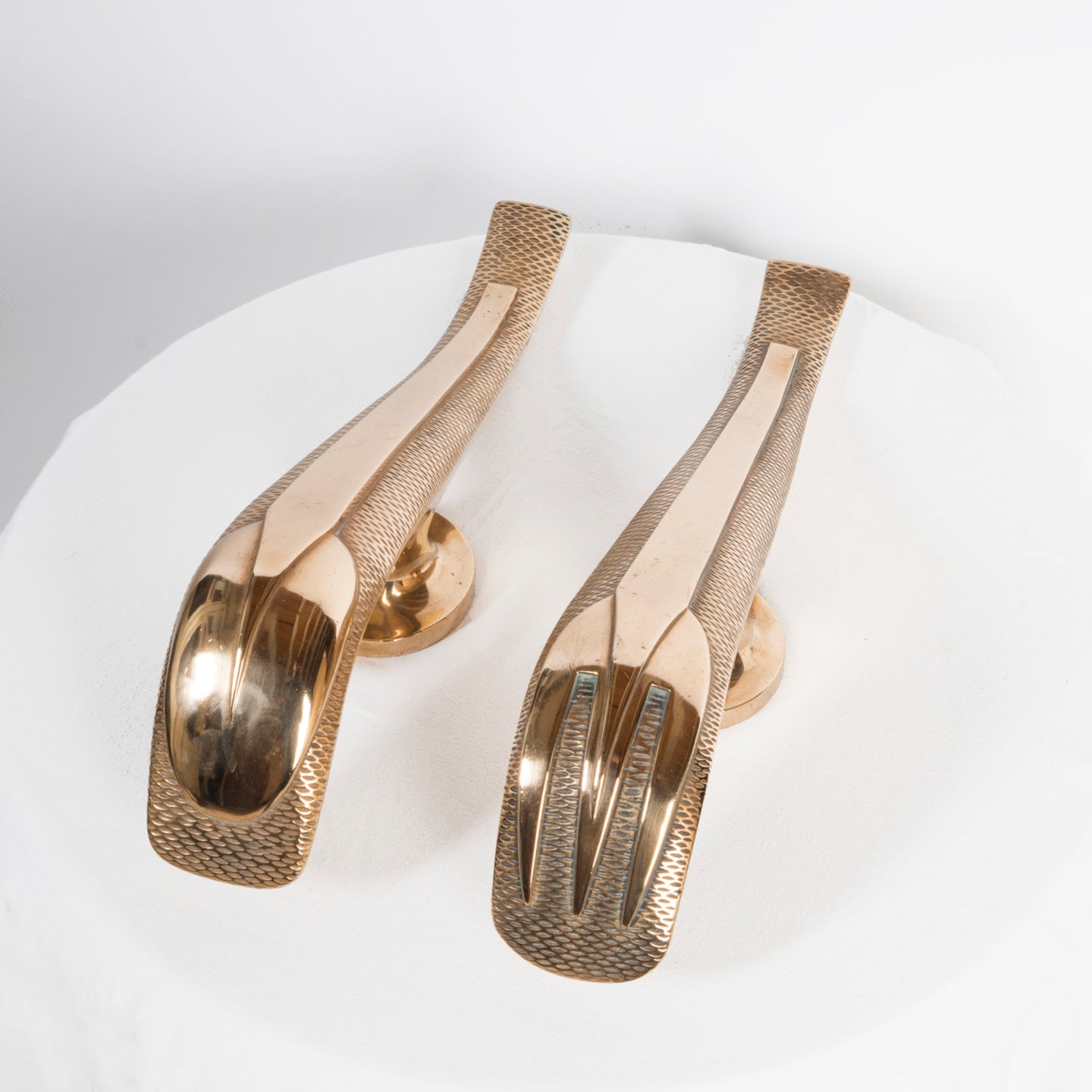 Top view of a unique and rare pair of gold-colored Art Deco style door pulls with a spoon and fork design, made of shiny brass