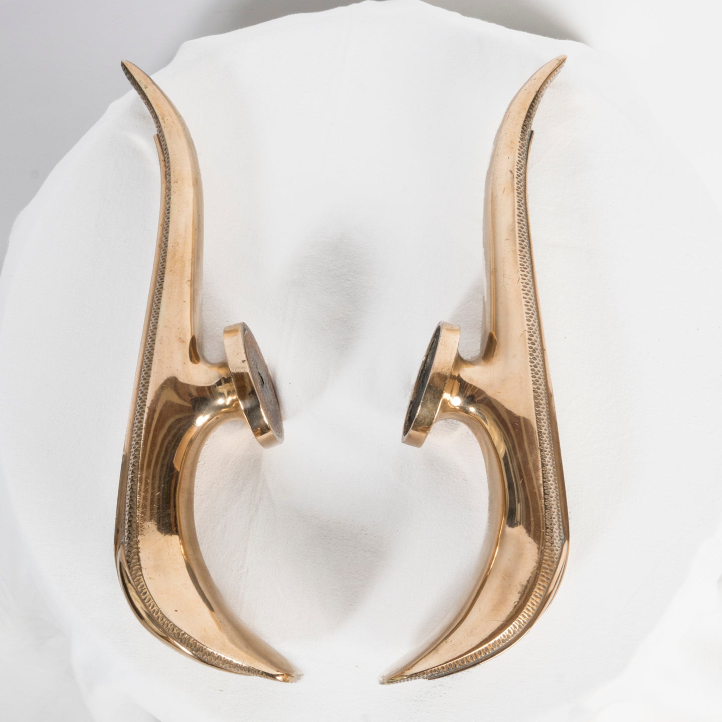 Sideview of a unique and rare pair of gold-colored Art Deco style door pulls with a spoon and fork design, made of shiny brass