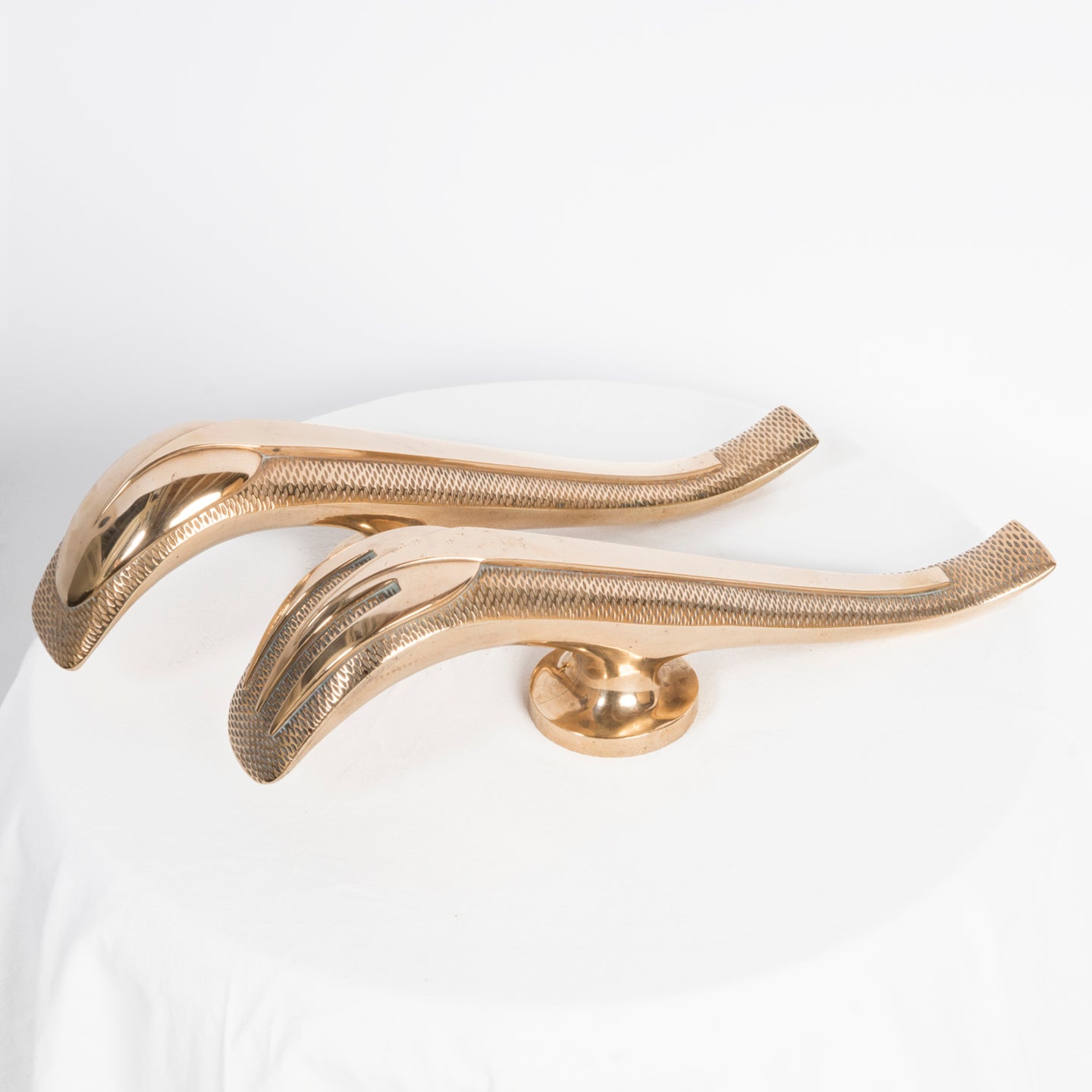 Top sideview of a unique and rare pair of gold-colored Art Deco style door pulls with a spoon and fork design, made of shiny brass