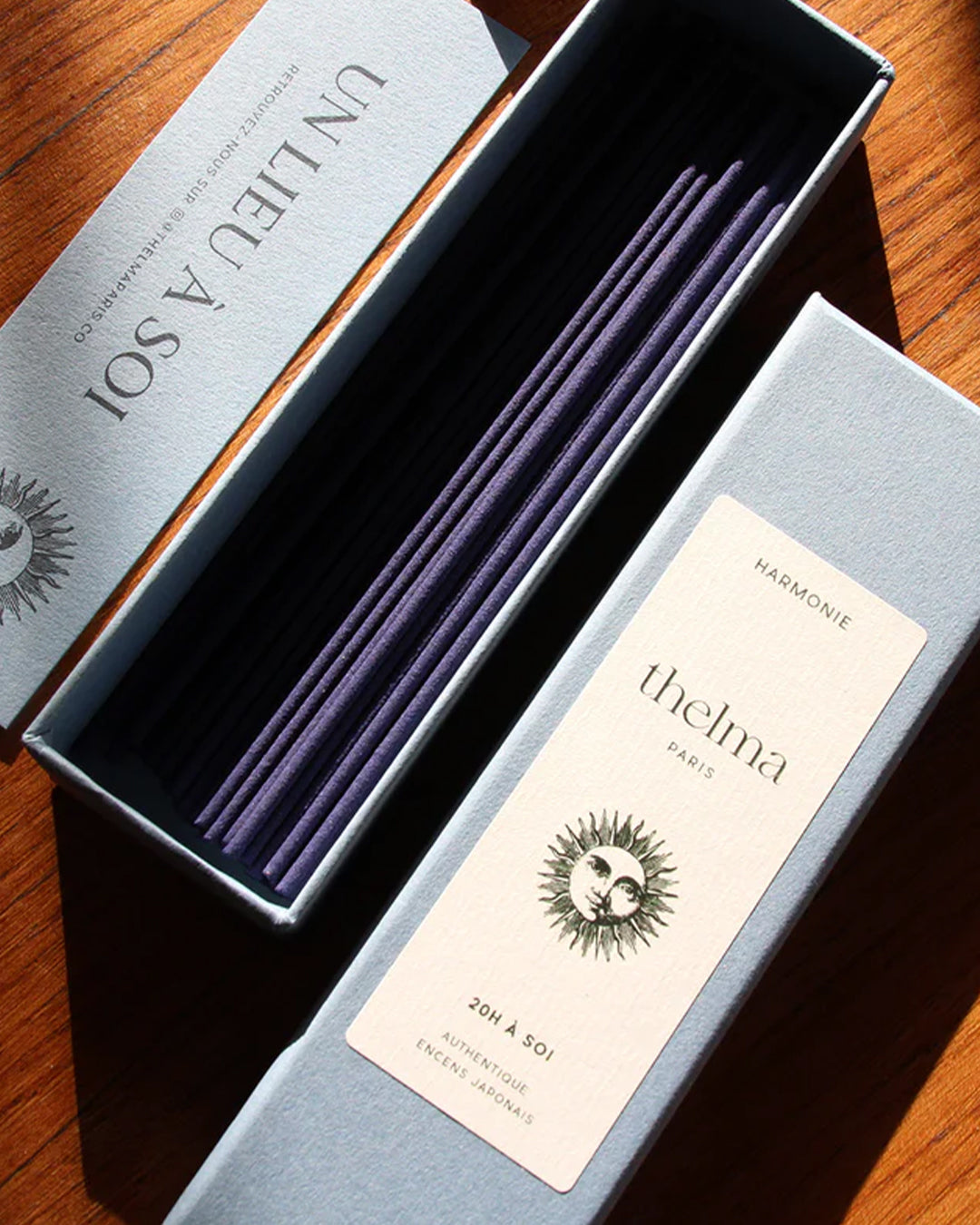 A package of Thelma Paris Harmonie incense with several blue sticks visible inside the box, placed on a wooden surface, available at Wildschut Antiques