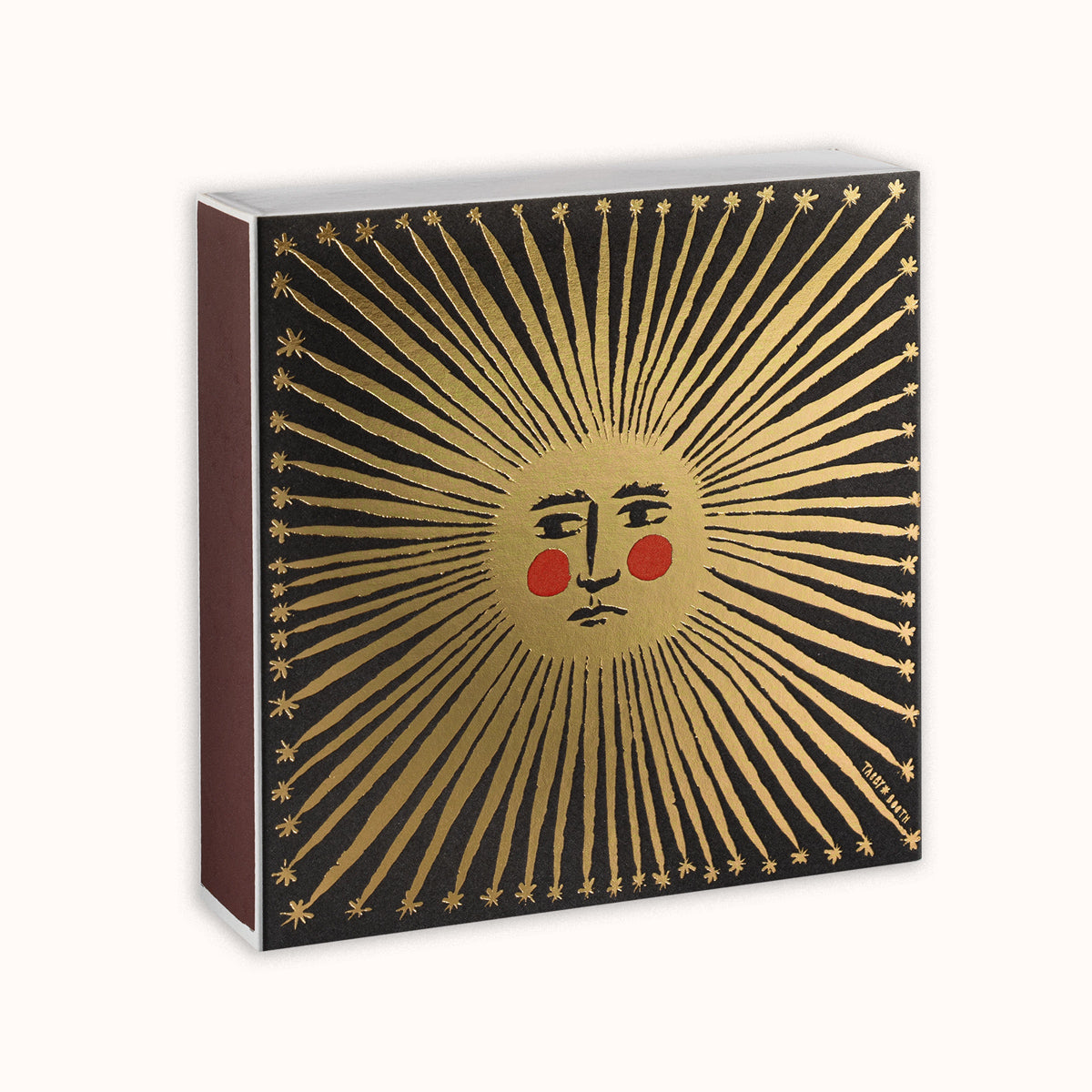 Matches in a decorative Archivist Gallery matchbox featuring a golden sun motif, displayed on a white background, available at Wildschut Antiques.
