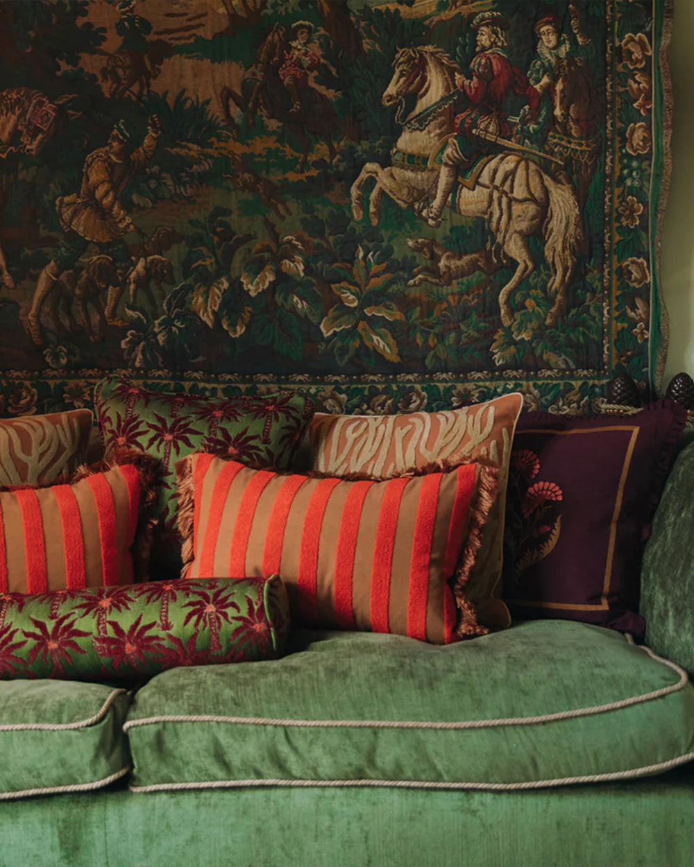 Classic interior with a Aubusson tapestry and a green sofa filled with pillows