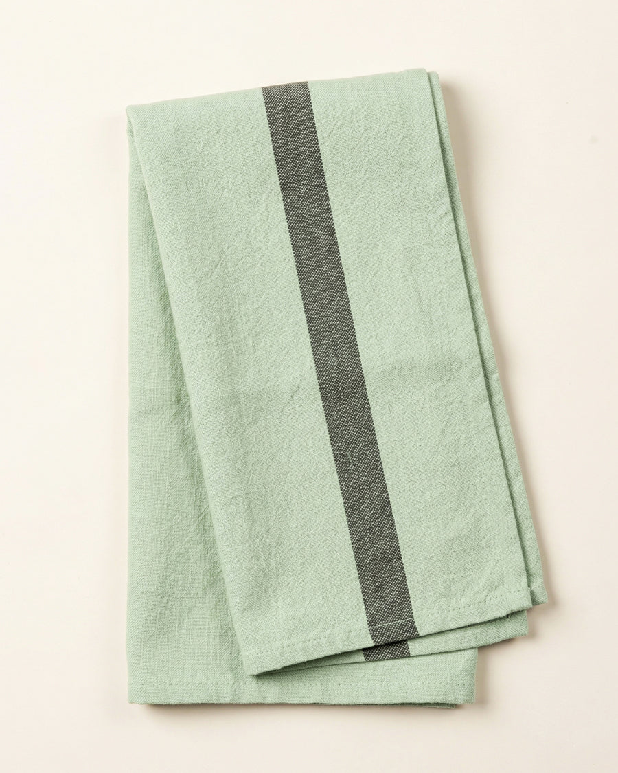 Light green linen towel with a dark stripe on a light background, by Charvet Editions available via Wildschut Antiques.