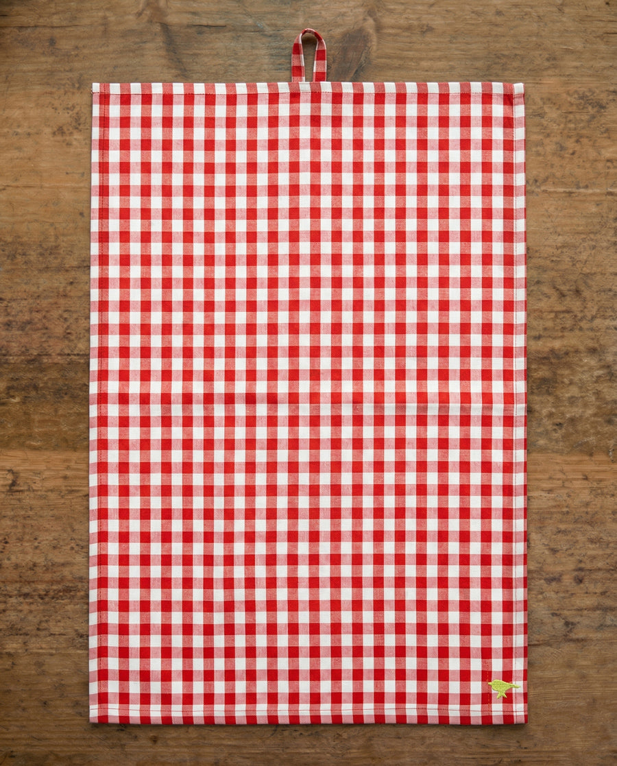 Red and white checkered towel on a wooden surface, available via Wildschut Antiques.