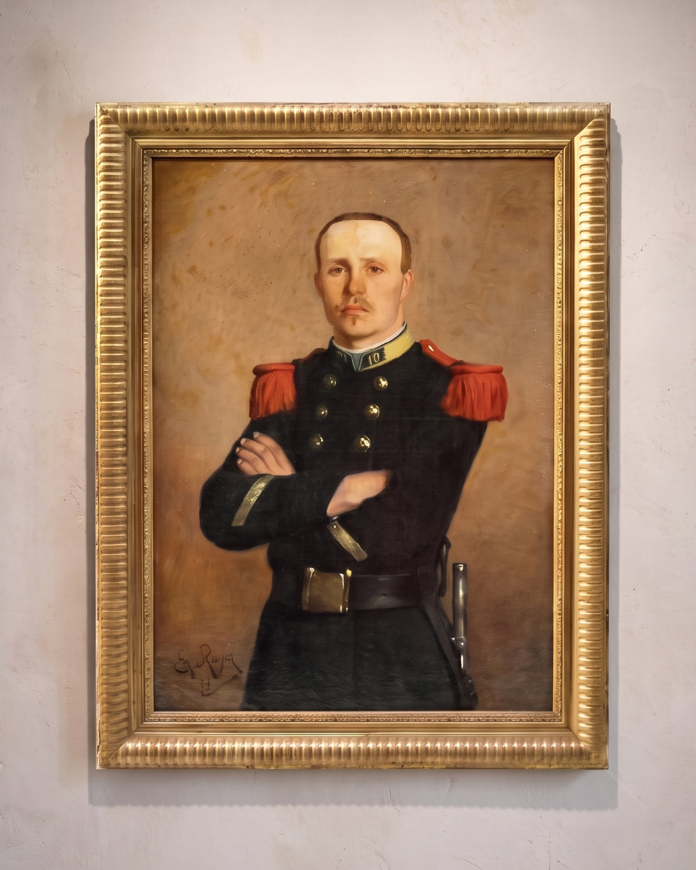 A framed historical portrait painting of a man in a dark military uniform with red shoulder epaulets, hanging on a light-colored wall.