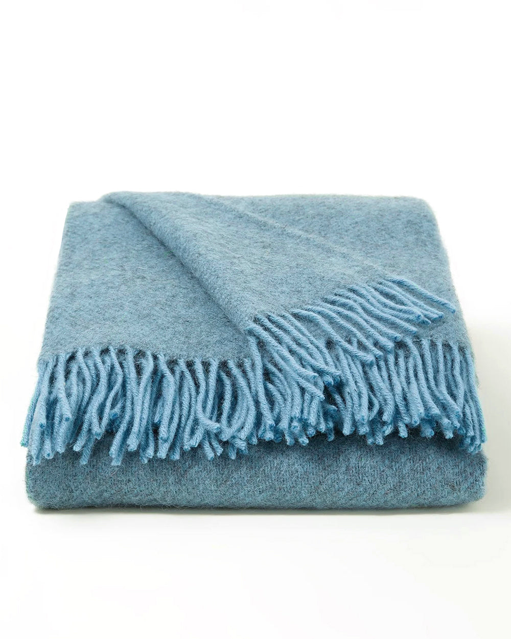 Neatly folded light blue wool blanket with fringes on a white background, by Klippan 1879, available at Wildschut Antiques.
