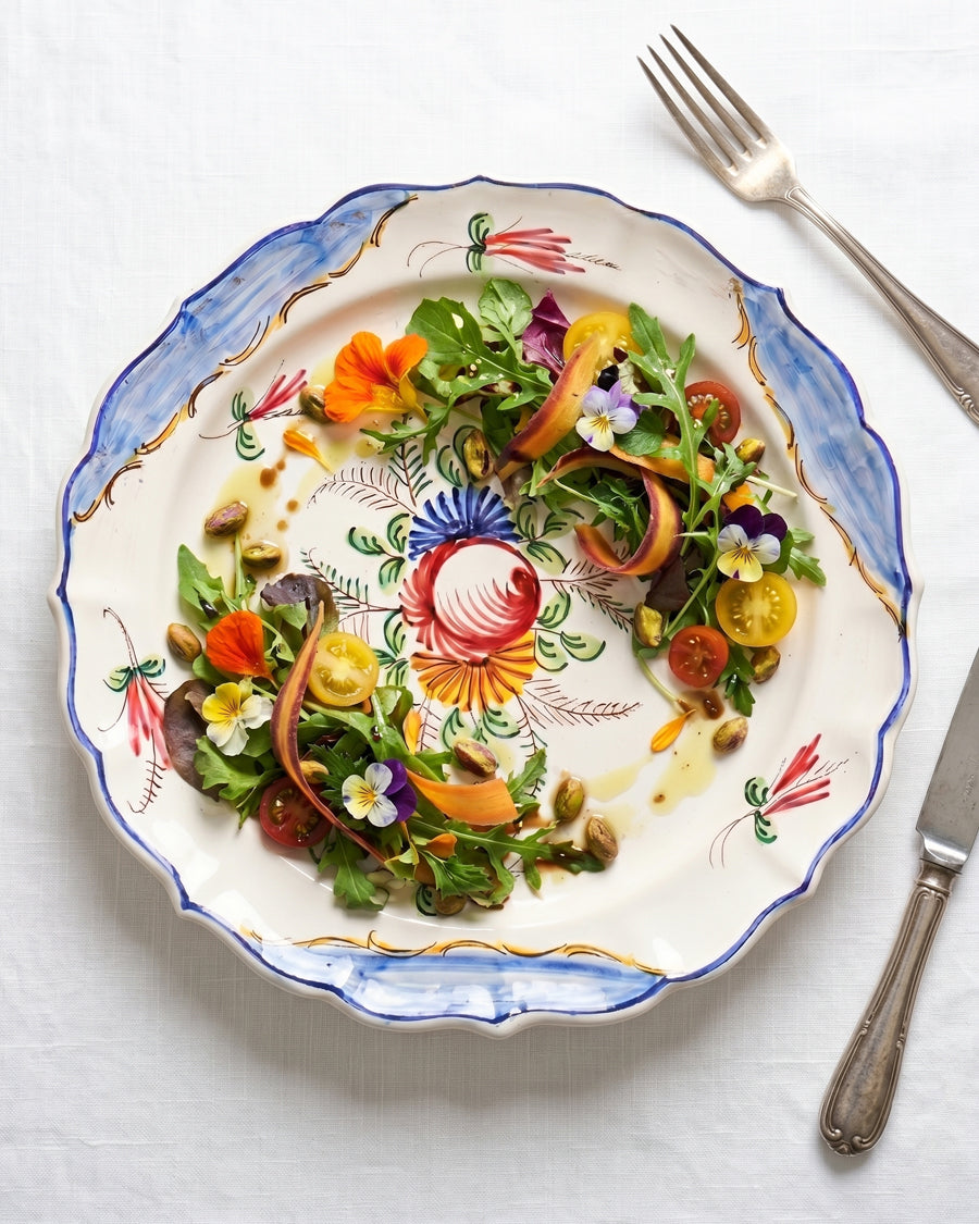 Decorative vintage hand-painted Italian plate featuring a colourful salad and utensils displayed on a white background, available at Wildschut Antiques.
