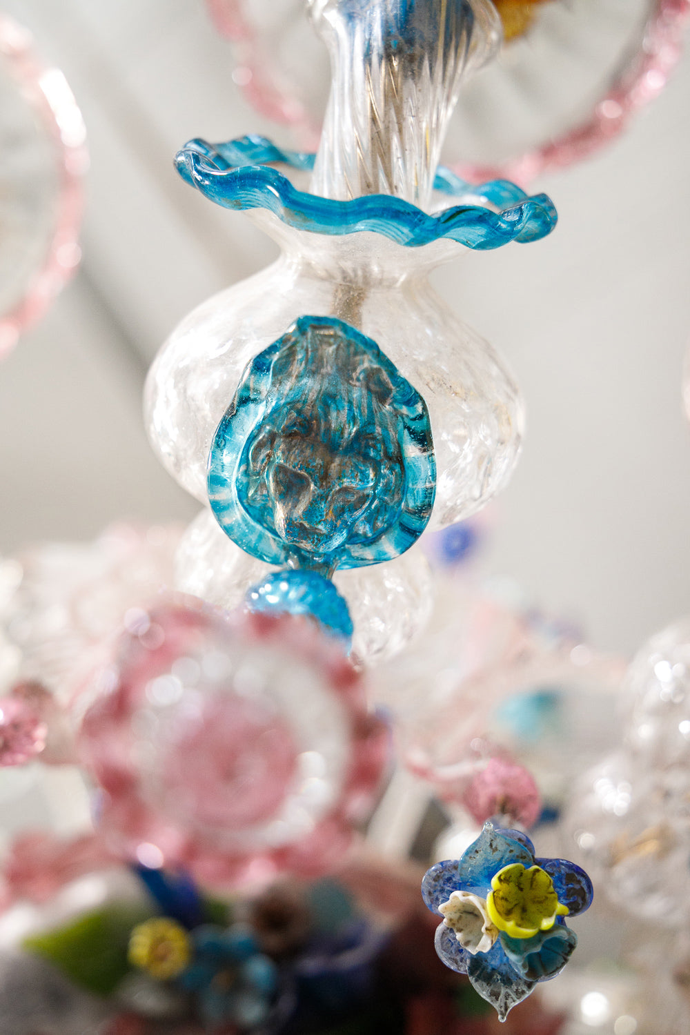 Decorative glass ornament in the shape of a lions head, symbol of Venice, belonging to a colorful vintage Venetian Murano Glass chandelier, available via Wildschut Antiques