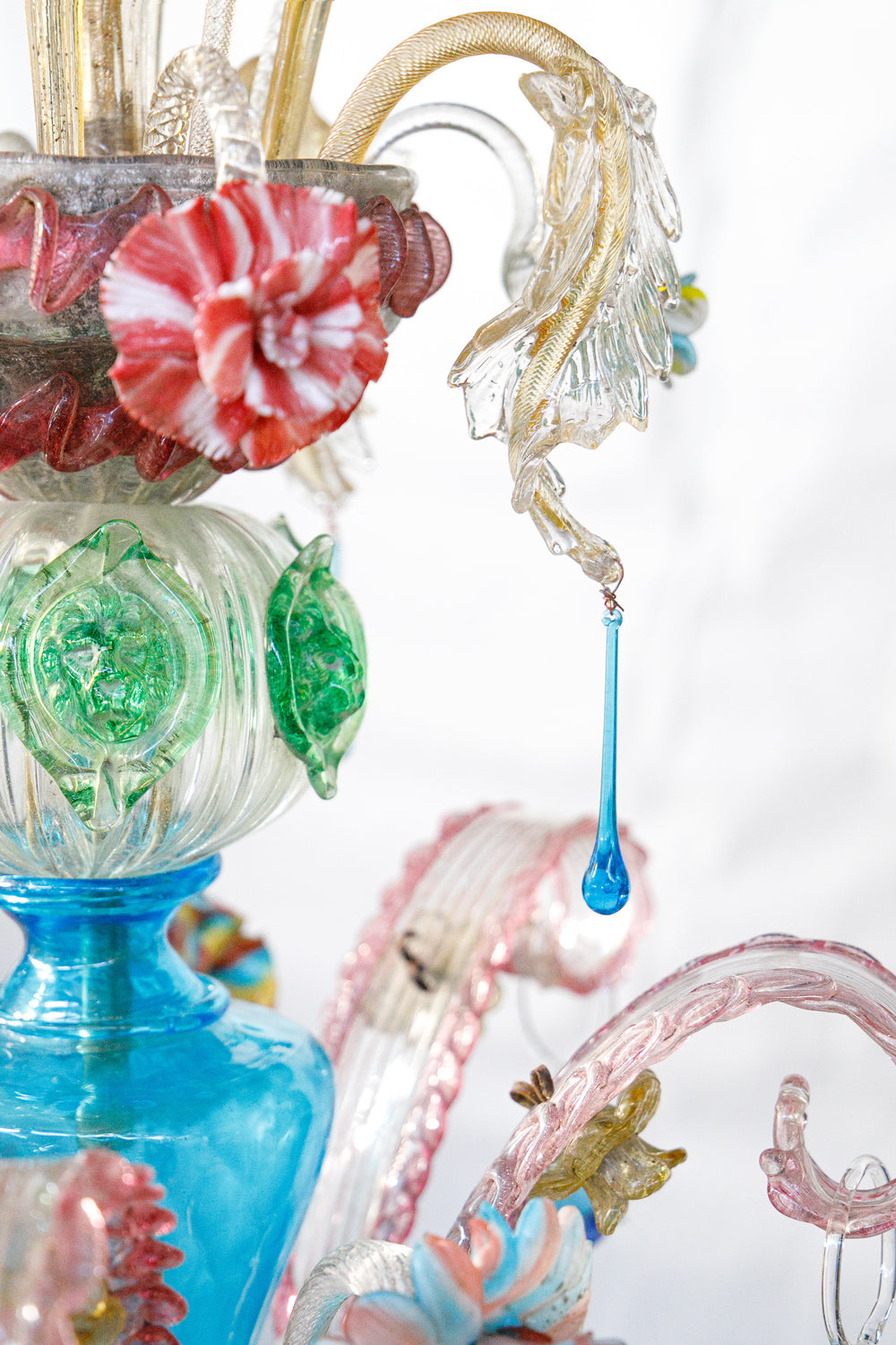 Close-up of a colorful vintage Venetian Murano glass chandelier with intricate designs on a white background, available via Wildschut Antiques