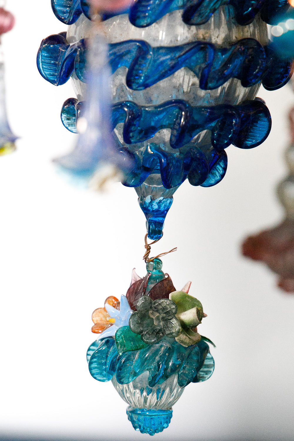 Decorative glass ornament with blue and clear flower design, belonging to a colorful vintage Venetian Murano Glass chandelier, available via Wildschut Antiques