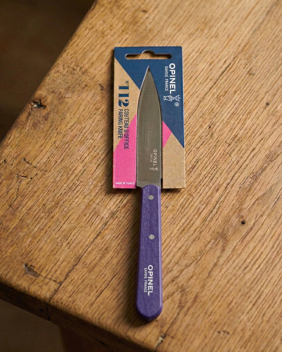 Opinel knife with purple handle and blue blade on a wooden surface, available via Wildschut Antiques