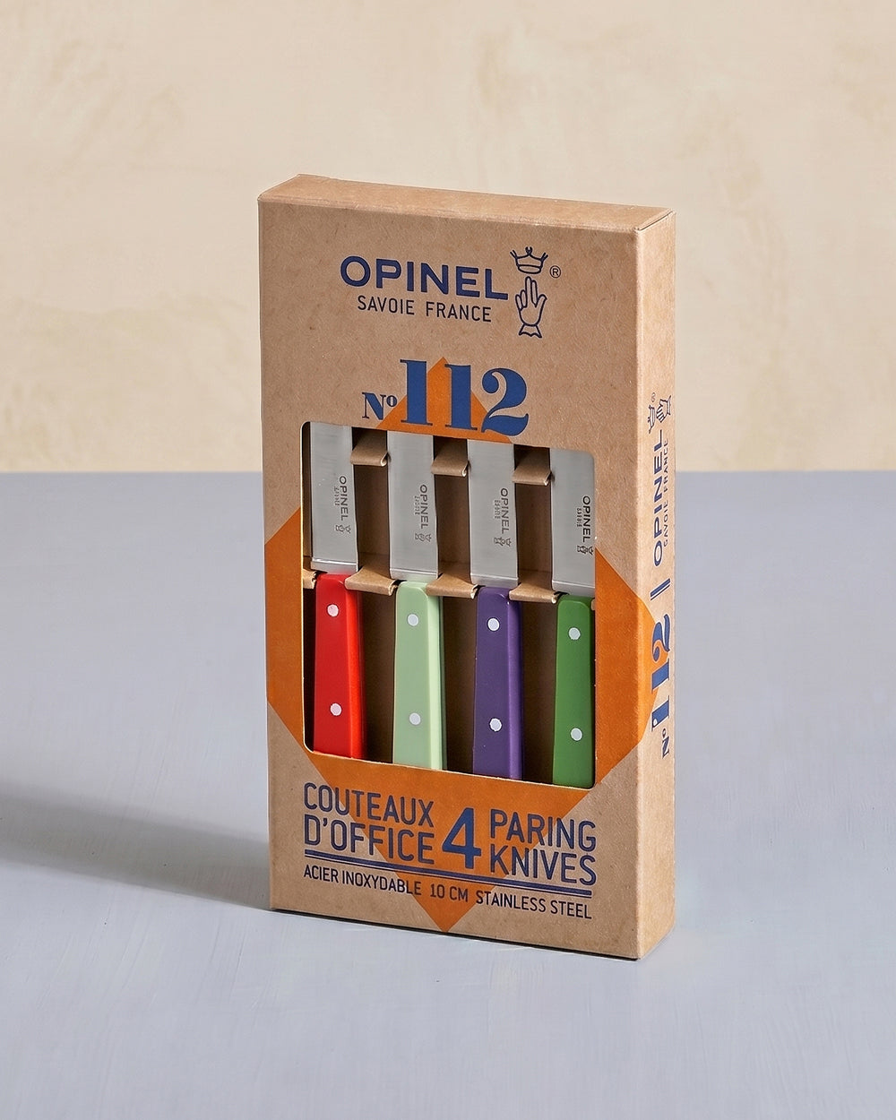 Opinel knife set packaging with four knives in different colors on a beige background. Available at Wildschut Antiques.

