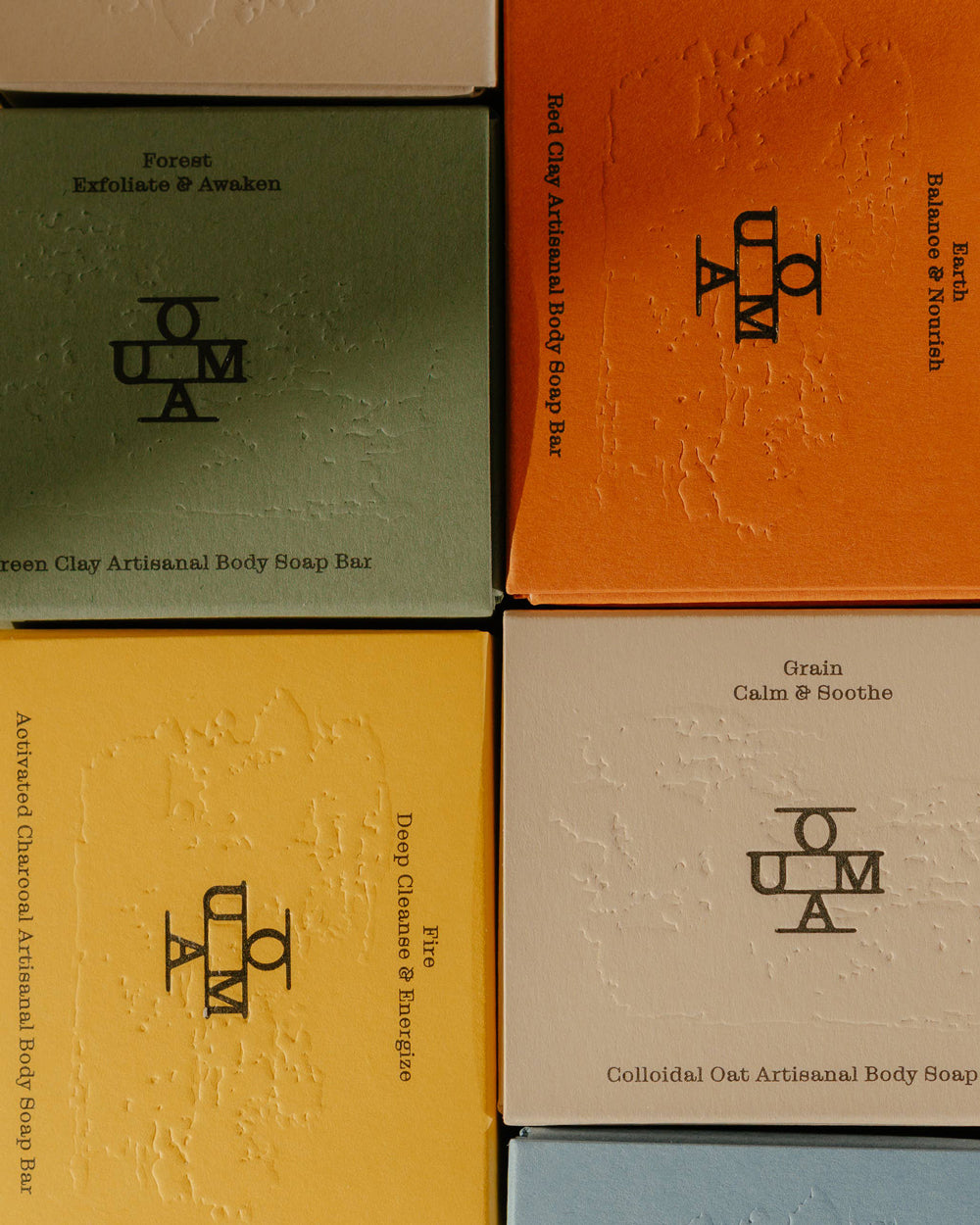 Four boxes of OUMA body soap bars in different colors with branding. Available at Wildschut Antiques & Decor.