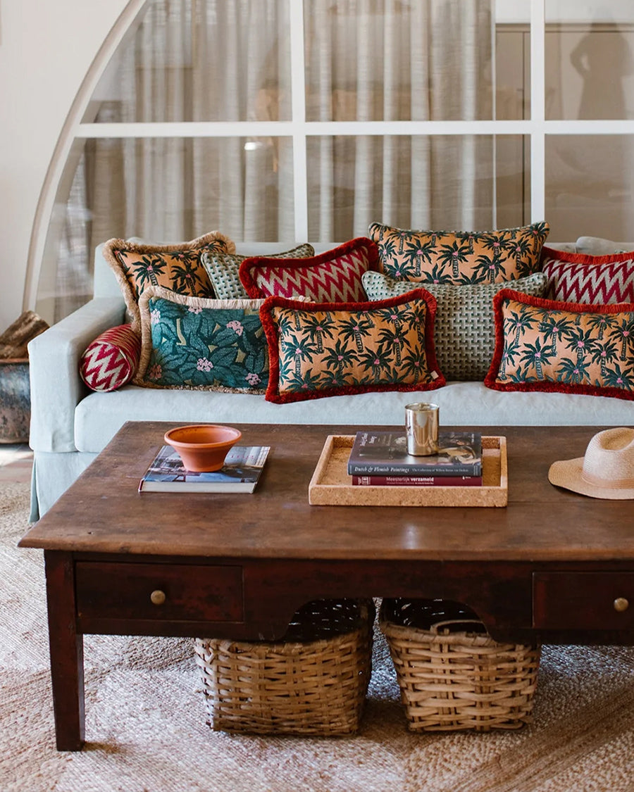 Living room with a white sofa adorned with colorful pillows bu Dutch brand Palais and a wooden coffee table.