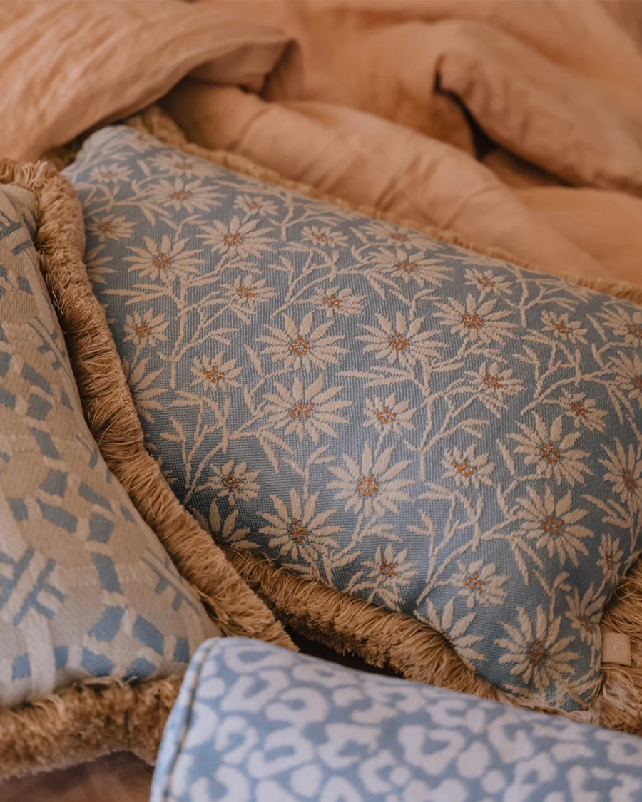 Close-up of patterned pillows with floral designs on a textured surface by Dutch brand Palais, available via Wildschut Antiques.