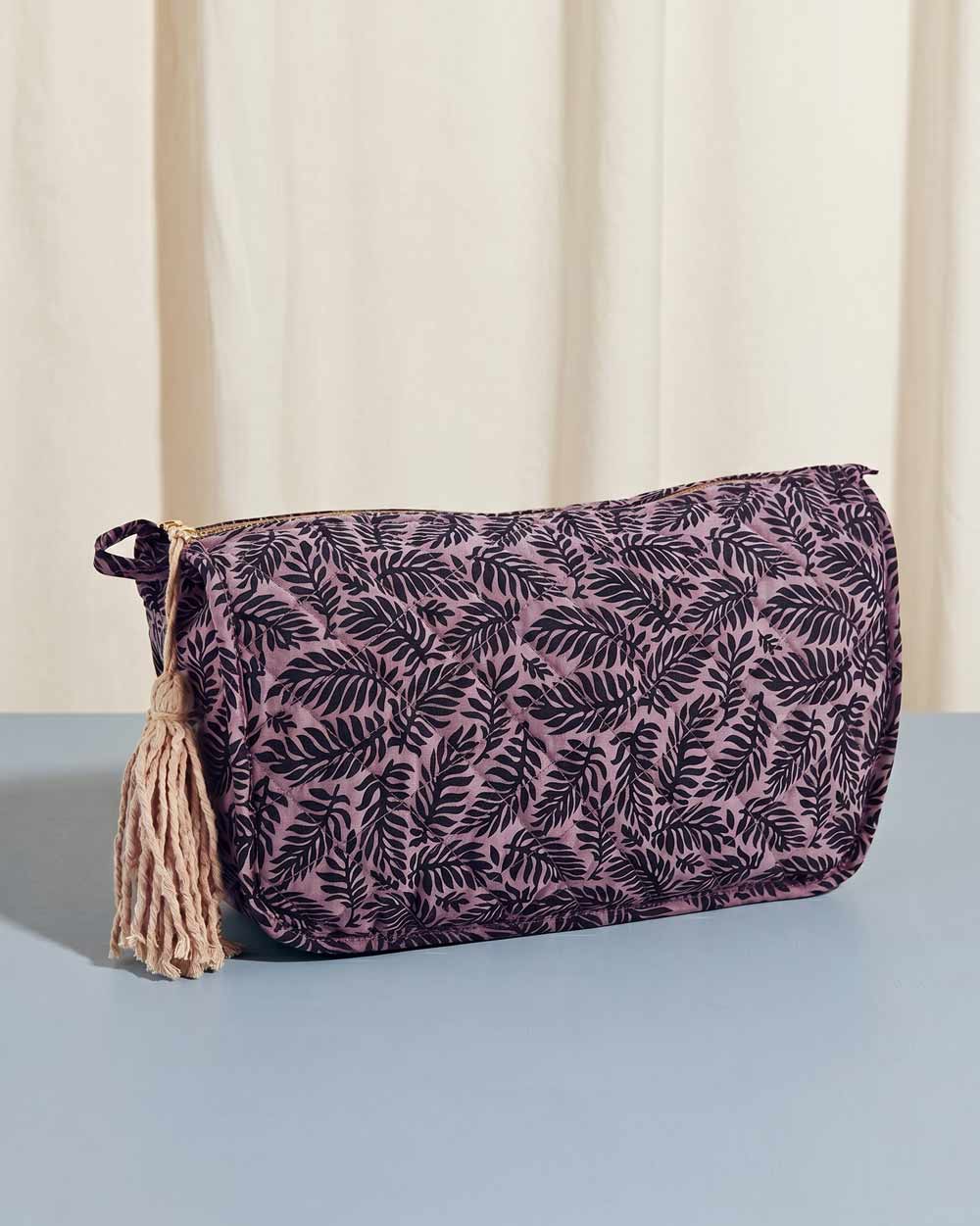Purple toiletry bag with leaf pattern and decorative tassel, displayed on a light blue background, available at Wildschut Antiques.