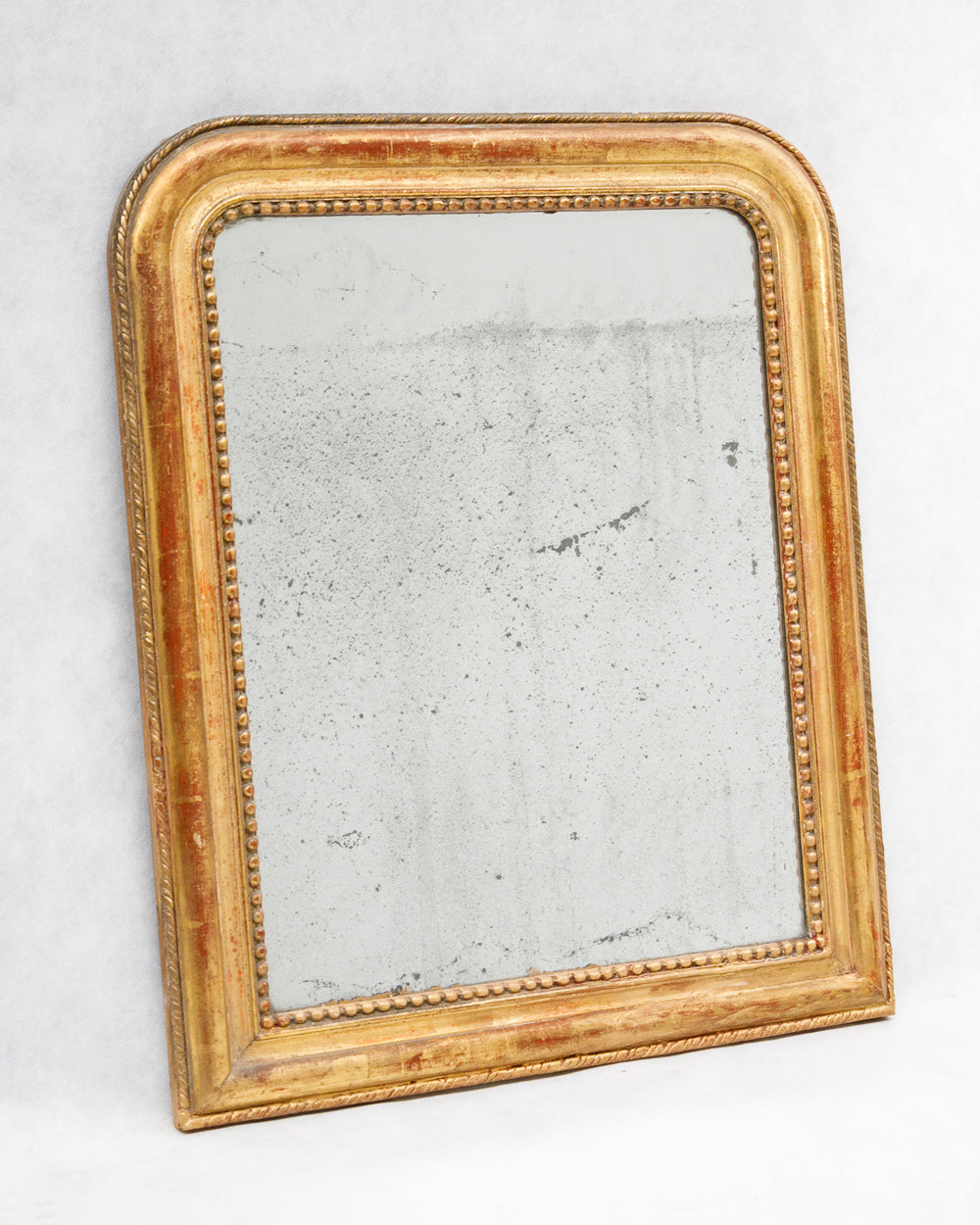 Antique-style gold-framed mirror on a white background