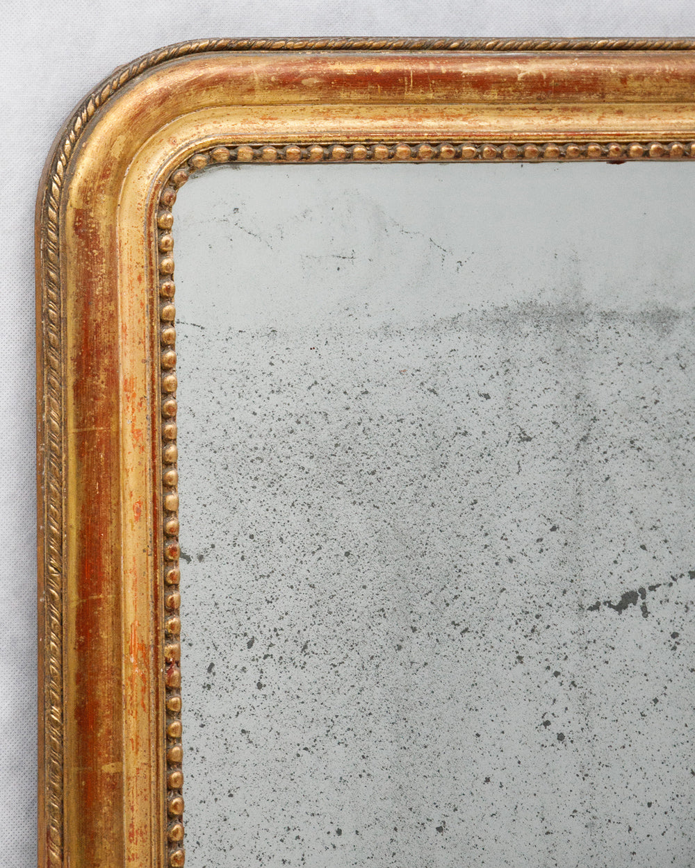 Detail of gold-framed antique French Louis Philippe mirror with foxed glass, available via Wildschut Antiques