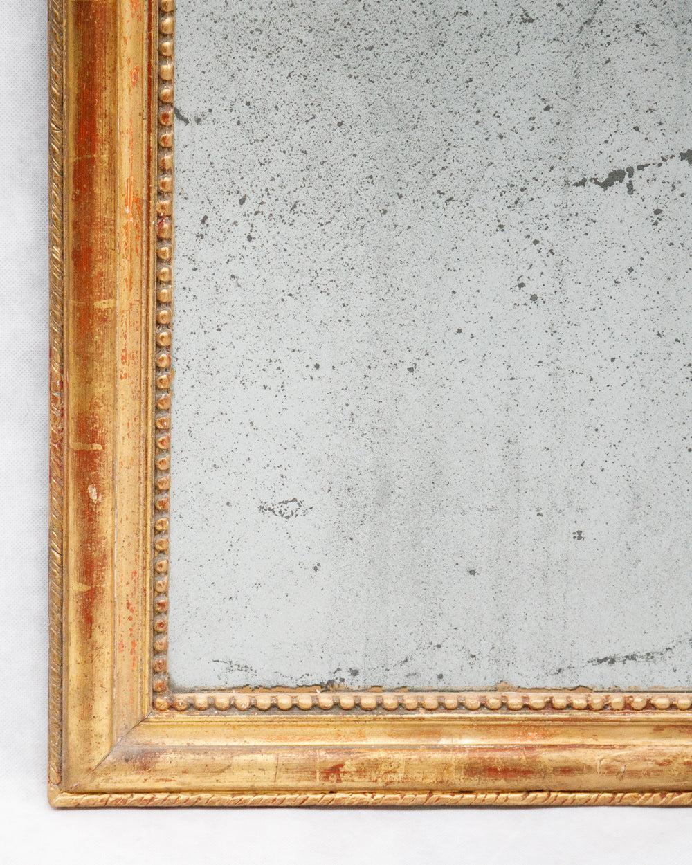 Detail of gold-framed antique French Louis Philippe mirror with foxed glass, available via Wildschut Antiques