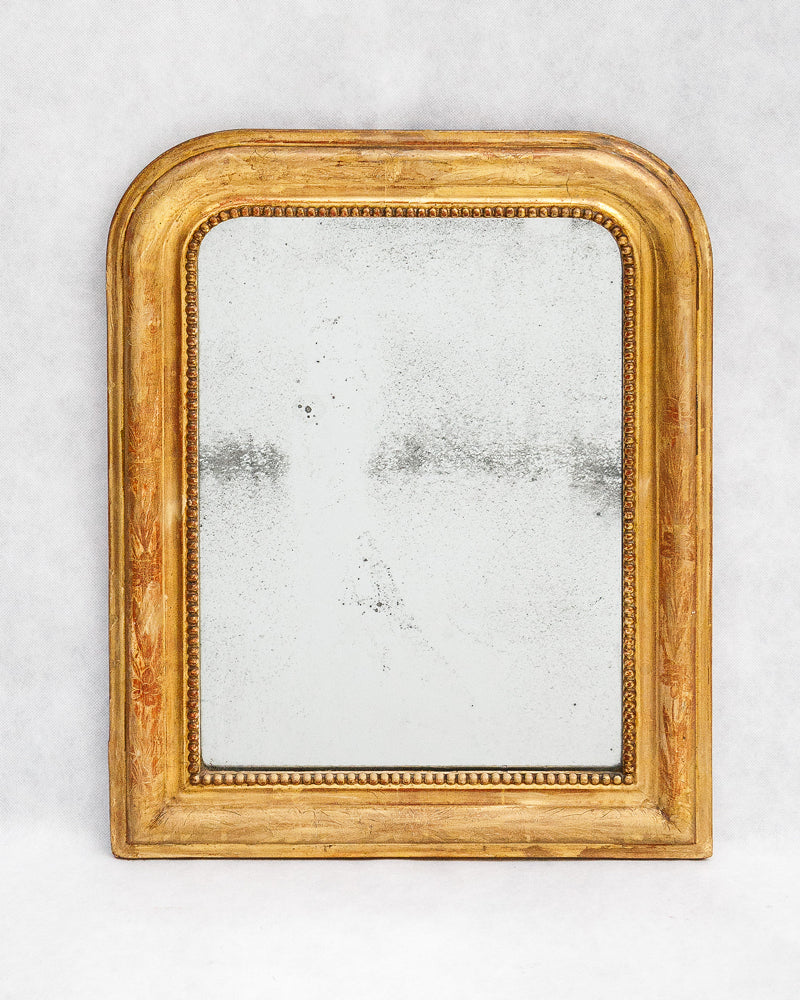 Antique French gold-framed Louis Philippe mirror with foxed mirror glass on a white background, available at Wildschut Antiques.
