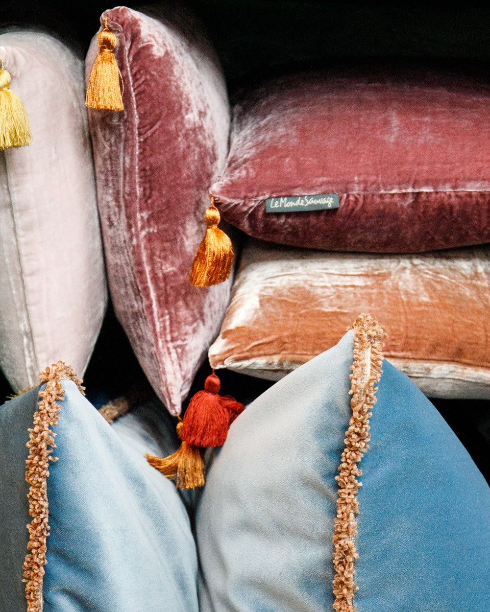Stack of decorative velvet pillows with tassels in soft pink and blue hues, part of the Homeware Pillow Collection by Wildschut Antiques