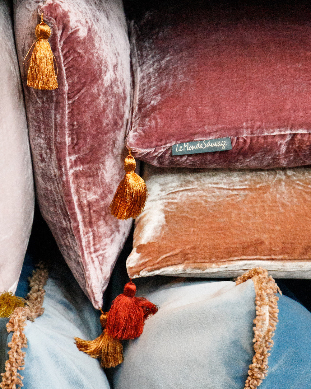 Close-up of plush velvet pillows with tassels, in soft pink and blue hues, part of the Homeware Pillow Collection by Wildschut Antiques